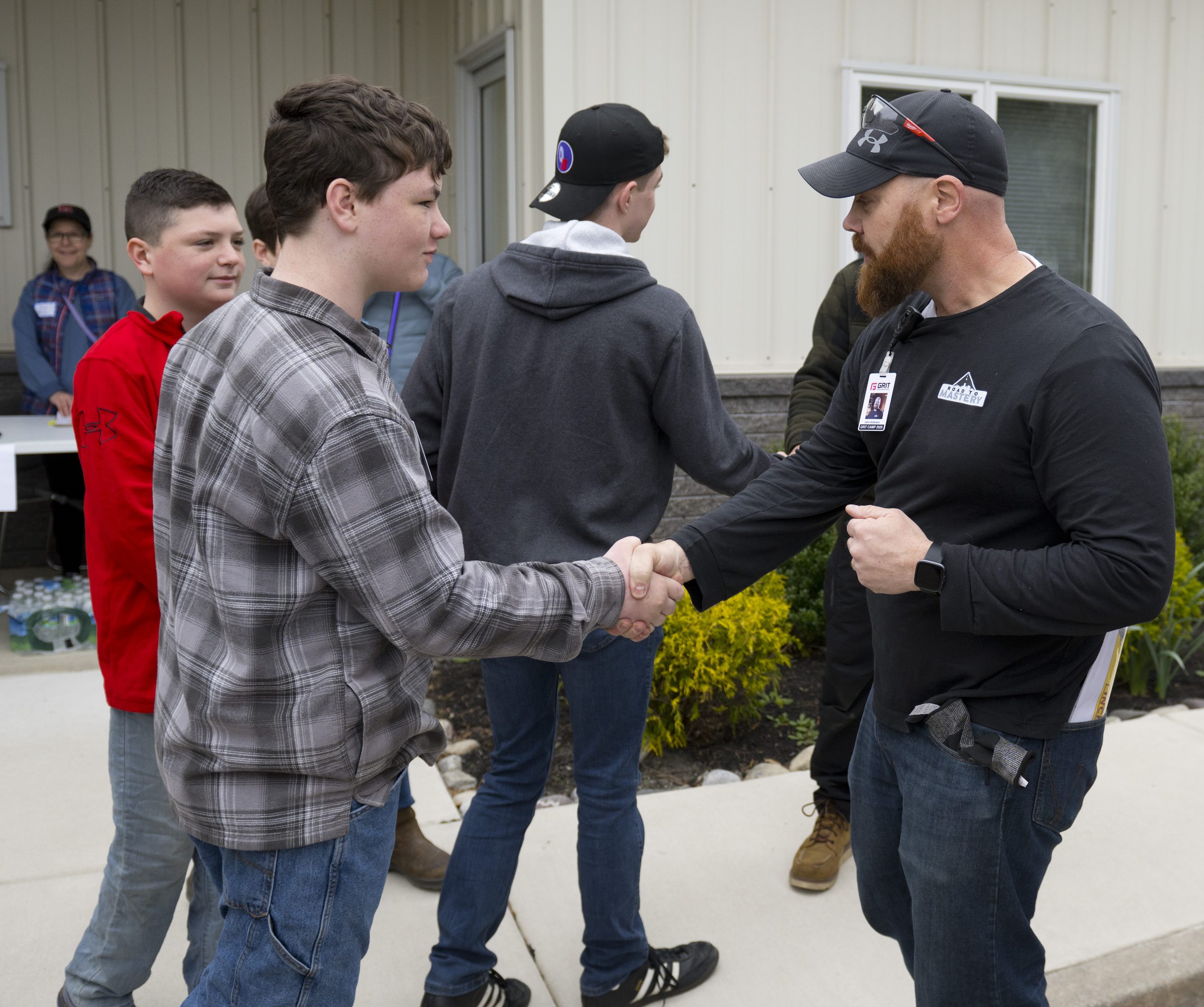 A GRIT mentor greets a student at a camp event.