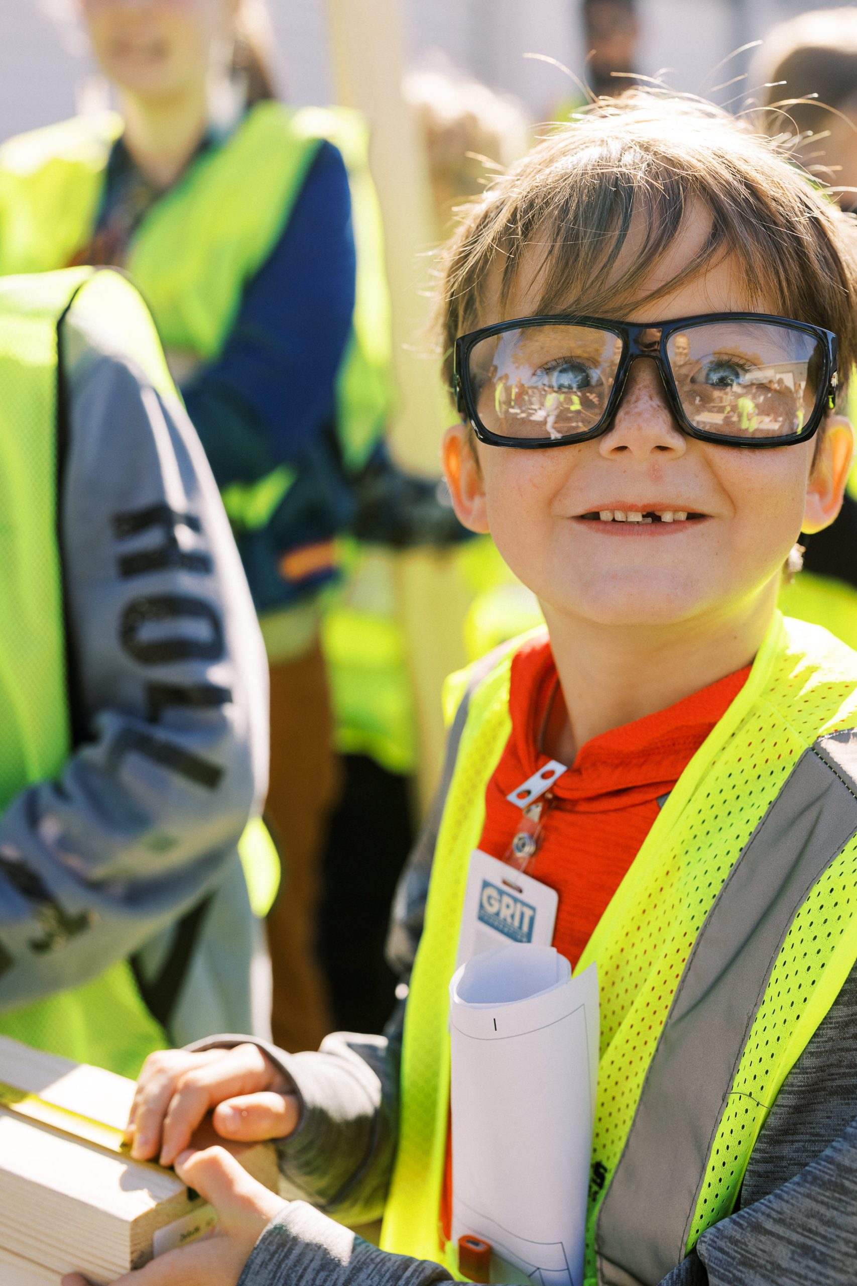 A GRIT camp participant wearing safety glasses and a high-visibility vest